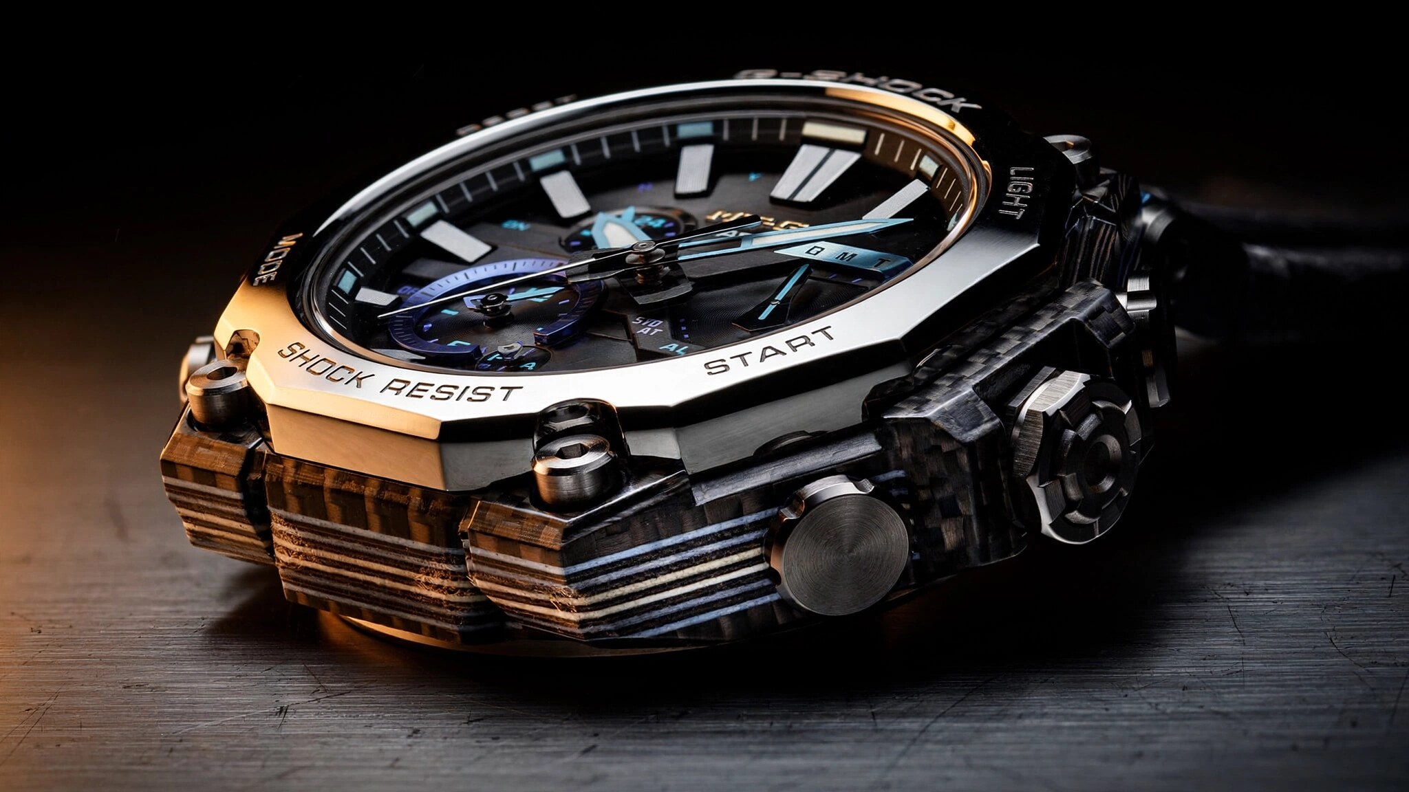 Close-up macro photograph of a G-Shock MTG-B4000 showing the layered carbon fiber frame edge and Sallaz-polished stainless steel bezel
